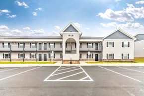 Youngsville apartment for rent - A large building with a parking lot in front of it.