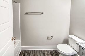Youngsville apartment for rent - A white toilet sits in a bathroom next to a white door.