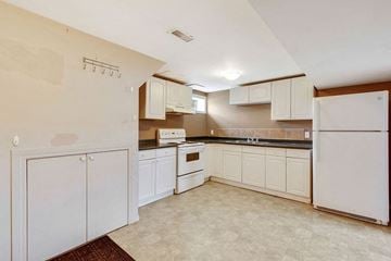 Calgary apartment for rent - a kitchen with white cabinets and a white refrigerator