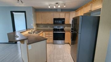 Edmonton house for rent - a kitchen with wooden cabinets and stainless steel appliances