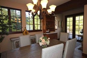 Whitefish house for rent - a dining room with a wooden table and chairs and a chandelier