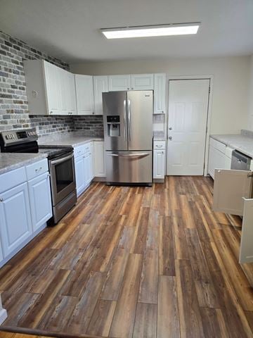 Mayslick house for rent - A kitchen with wooden floors and white cabinets.