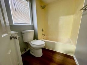 Louisville house for rent - A white toilet sits in a bathroom with yellow walls and a white door.