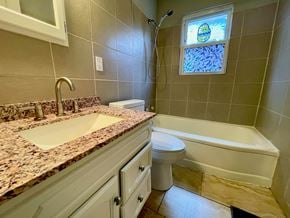 Louisville house for rent - A bathroom with a sink, toilet, and bathtub.