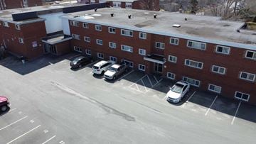 Dartmouth apartment for rent - A parking lot with a red car and a white van.