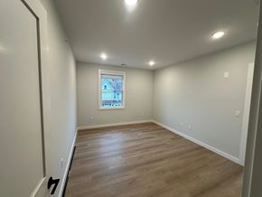 Warwick apartment for rent - A room with wooden flooring and a window showing a view of a house.