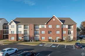 Conway apartment for rent - A large brick building with a parking lot in front.