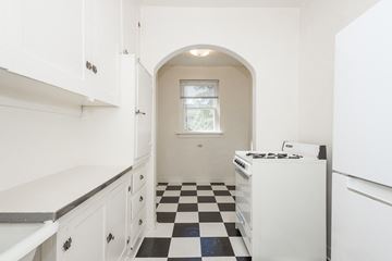 Denver apartment for rent - A kitchen with white cabinets and a black and white checkered floor.