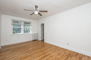 Denver apartment for rent - A room with a ceiling fan and a window with a view of trees.