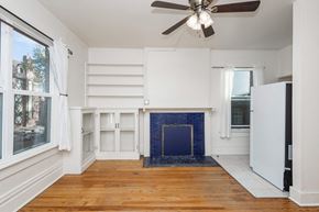 Denver apartment for rent - A room with a fireplace and a ceiling fan.