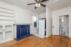 Denver apartment for rent - A room with a fireplace and a ceiling fan.