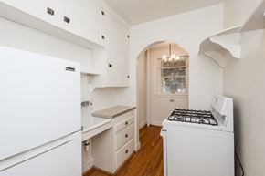 Denver apartment for rent - A white fridge in a kitchen with wooden floors and a white stove.