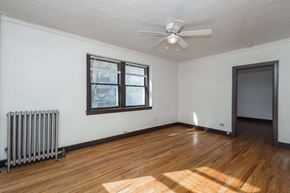 Denver apartment for rent - A room with a ceiling fan and a radiator on the wall.