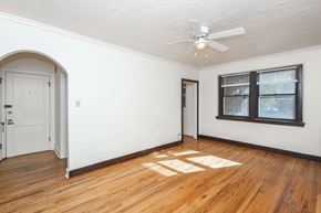 Denver apartment for rent - A room with a white ceiling fan and a window with black frames.