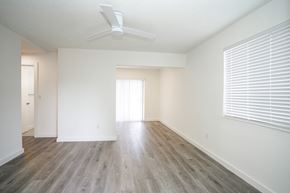 Miami apartment for rent - an empty living room with wood floors and a ceiling fan