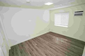 Miami apartment for rent - a bedroom with green walls and a wood floor