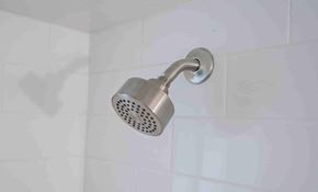 Miami apartment for rent - a shower head in a white tiled bathroom
