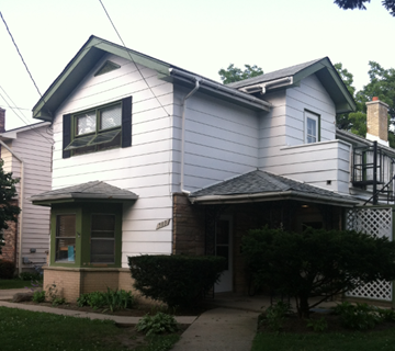 Waukegan apartment for rent - a white house with a black window and a sidewalk