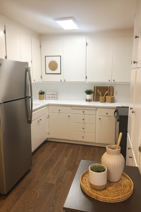 San Jose apartment for rent - A kitchen with a refrigerator, wooden table, and white cabinets.