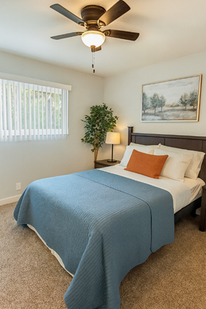 San Jose apartment for rent - A bedroom with a bed, a ceiling fan, and a painting on the wall.