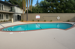 San Jose apartment for rent - A pool surrounded by a fence and a sign on the wall.