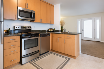 San Jose apartment for rent - A kitchen with wooden cabinets and a black stove top oven.