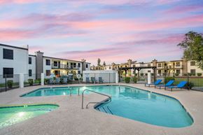 Phoenix apartment for rent - A swimming pool surrounded by lounge chairs and apartment buildings.