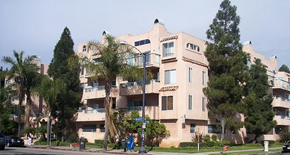 Long Beach apartment for rent - A large beige building with a balcony on the second floor.