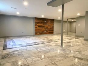 North Chicago house for rent - A spacious room with marble flooring and a wooden accent wall.