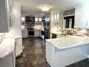 North Chicago house for rent - A kitchen with white cabinets and a marble countertop.