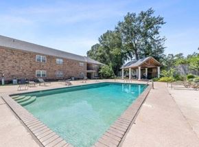 Lafayette apartment for rent - a swimming pool in front of a brick building