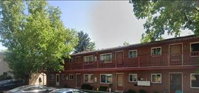 Boulder apartment for rent - a red brick apartment building with cars parked in front of it