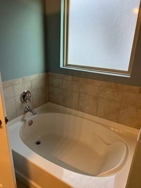 Youngsville house for rent - a bathroom with a bath tub and a window