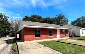 Gulfport house for rent - A red brick house with a white garage door.