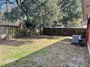 Gulfport house for rent - A backyard with a fence and a tree.