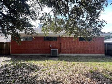 Gulfport house for rent - A red brick building with a tree in front.