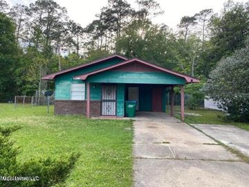 Gulfport house for rent - A green and red building with a green door and a green trash can in front of it.
