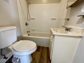 Louisville apartment for rent - A white toilet sits next to a white sink in a small bathroom.