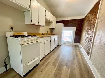 Louisville apartment for rent - A kitchen with a white gas stove and white cabinets.