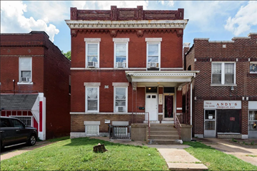 St. Louis house for rent - the front of a red brick building with steps and a lawn