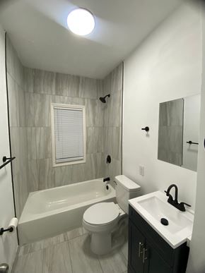 Louisville apartment for rent - A white toilet sits next to a bathtub in a bathroom.