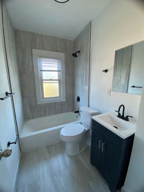 Louisville apartment for rent - A bathroom with a white tub, toilet, and sink.