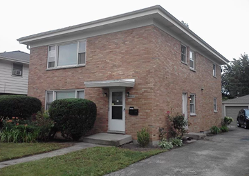 Waukegan house for rent - A brick house with a white door and windows.