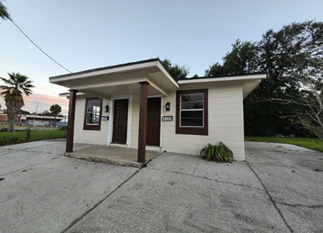 Jacksonville house for rent - A small white house with a brown door and windows.