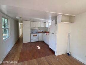 Interlachen house for rent - an empty kitchen with white cabinets and a wooden floor