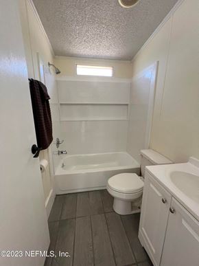 Interlachen house for rent - A small white bathroom with a toilet, sink, and bathtub.