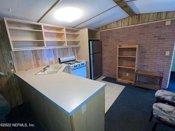 Interlachen house for rent - A kitchen area with a refrigerator, sink, and cabinets.