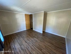 Interlachen house for rent - A room with wooden flooring and a door in the middle.