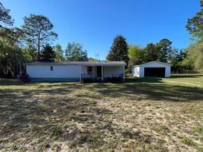 Interlachen house for rent - A white house with a garage is surrounded by trees.