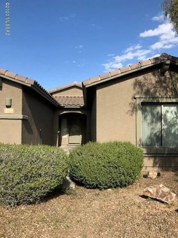 Tucson house for rent - a house with bushes in front of it